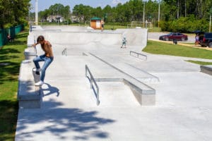 Clean nose grind at the skatepark while a girlfriend look on
