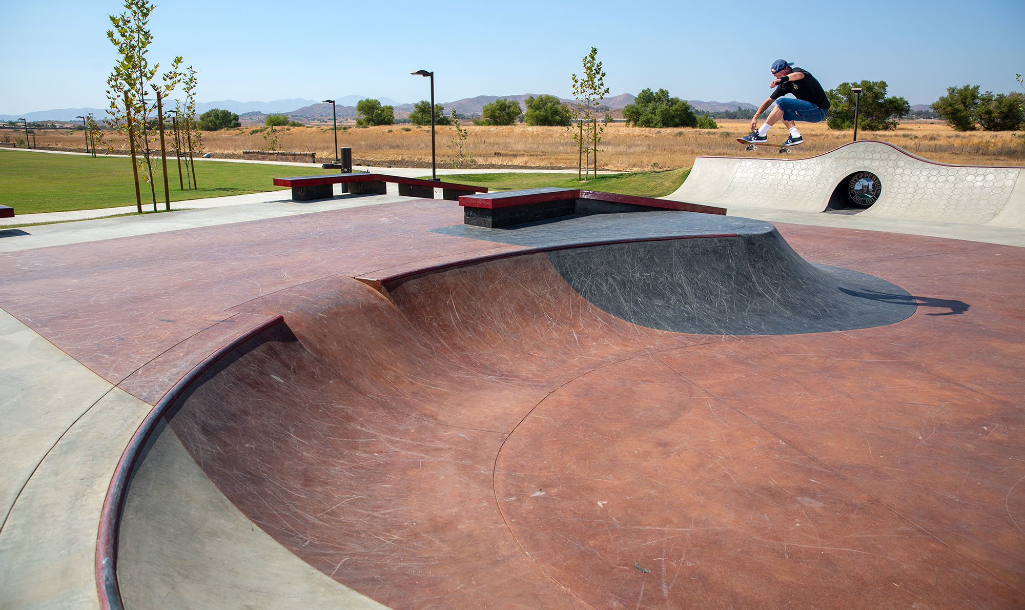 Jake Wooten whoops over the hip at Perris Skatepark