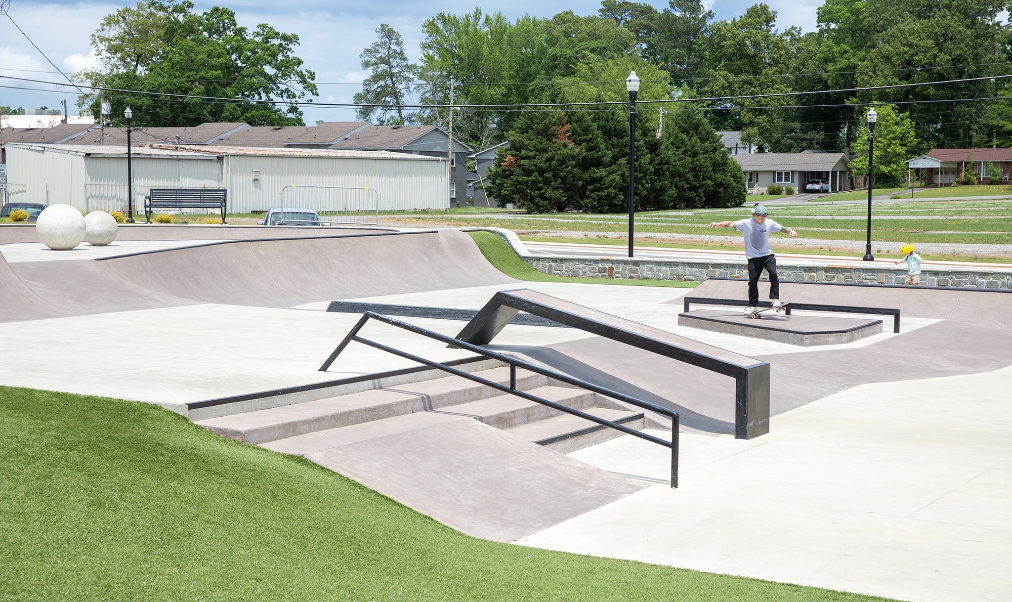 Cullman Skatepark's Manny Pad in Alabama with handrail and hubba in the foreground with a skateboard bowl in the back